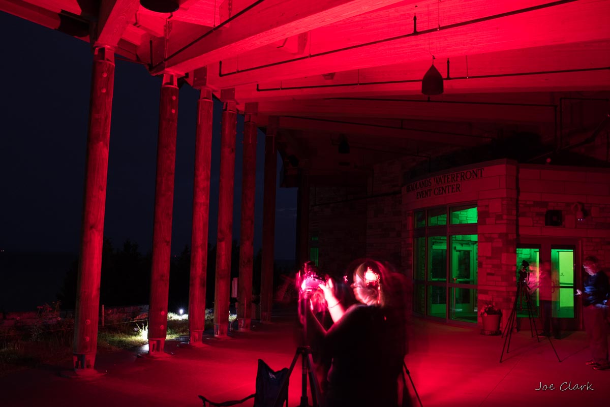 Students practicing night photography under red headlamps
